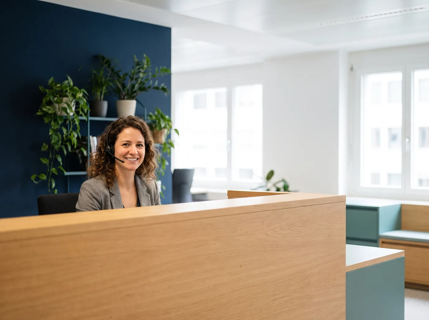 Empfang in einem hellen Büro mit Mitarbeiterin am Headset